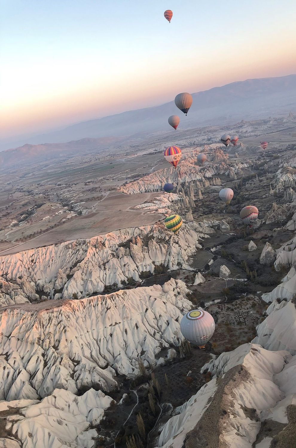 Hot-air balloons drifting over Cappadocia at dawn